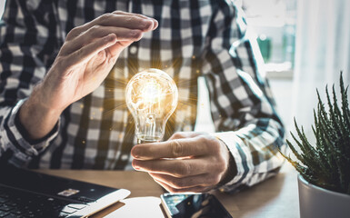 Businessman hand holding lightbulb with glowing virtual brain and connection line to creative smart...