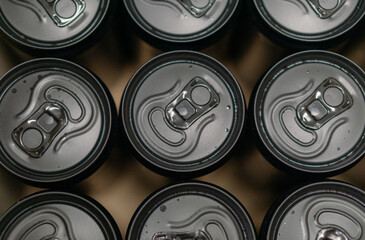 Background of black slim aluminium drink cans from top