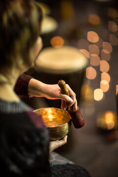 Woman playing on a tibetian singing bowl (shallow DOF; color toned image)