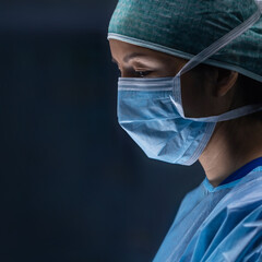 Team of medical doctors performs surgical operation in modern operating room using high-tech...