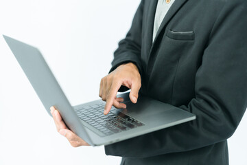 Businessman in half black suit standing left hand holding laptop The right hand is about to touch the keyboard. On a white background, oblique left corner.
