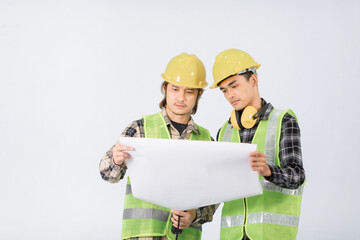 Two young Asian engineers in light green coats and yellow helmets are inspecting and checking collaboration on white background.