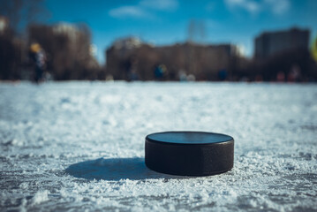 black hockey puck lies on ice at stadium