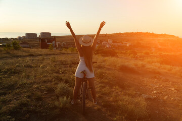Woman travel bike. Happy woman cyclist sitting on her bike, enjoying the beautiful mountain and sea...