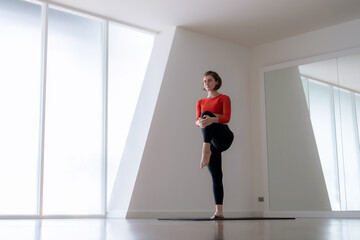 Caucasian woman exercising and stretching by practicing yoga.