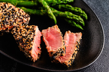 Tuna steak fried in sesame seeds served with asparagus.