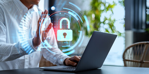 Businessman waving to the computer, cybersecurity hologram with lock icon