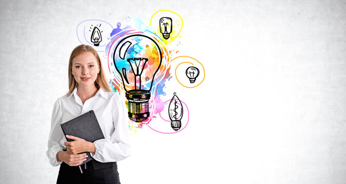 Smiling businesswoman with notebook, colorful lightbulbs on grey