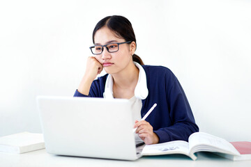 Closeup Asian young female student in casual cloth shows boredom in doing reports or homework with laptop on white gradient background. Asian school concept.