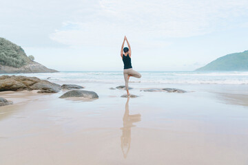 Fototapeta na wymiar With each mindful movement, a woman cultivates presence and awareness during her beach yoga practice, fully embracing the present moment and the beauty of the beach.