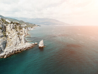 aerial photo of rock Parus Sail and Ayu-Dag Bear Mountain and near Gaspra, Yalta, Crimea at bright sunny day over the Black sea. Rock Parus in Gaspra near Swallow's nest in Crimea. - obrazy, fototapety, plakaty