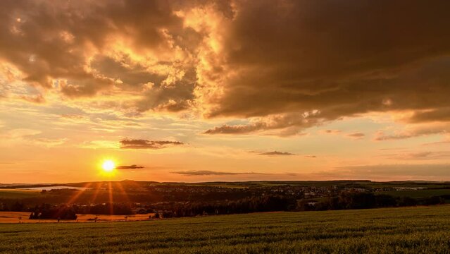 clouds crossing on sunset sky over small town time lapse