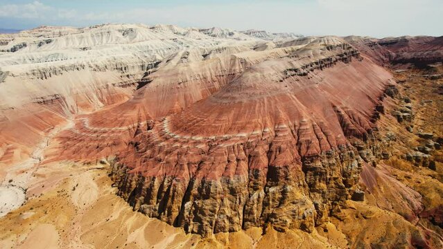 Beautiful Aktau mountains in Altyn-Emel National Park on a bright summer day. Red mountains formed by sedimentary rocks. Aerialview of sandy rocks in the wild.