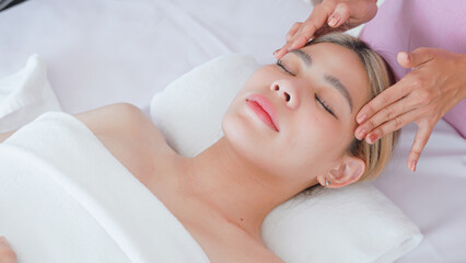 Fototapeta na wymiar Woman having facial massage by masseuse.