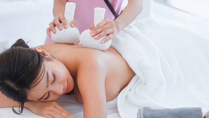 Obraz na płótnie Canvas Woman spa with Thai herbal ball hot compress massage.