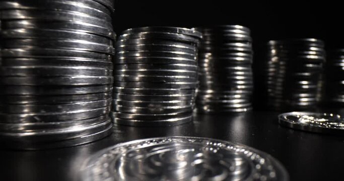 Stack of silver coins on black background. Black economy and monetary inflation