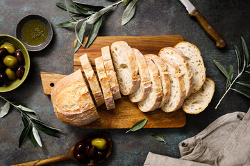 Ciabatta bread sliced on a board, top view - obrazy, fototapety, plakaty