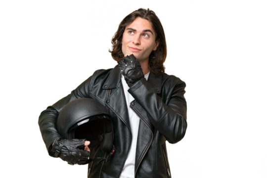 Young handsome man with a motorcycle helmet isolated on green chroma background and looking up