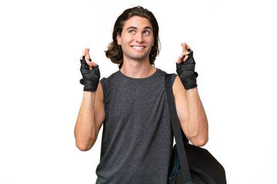 Young sport handsome man isolated on green chroma background with fingers crossing