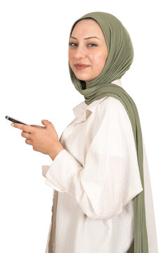 Using smartphone, profile portrait of smiling caucasian girl in hijab using smartphone. Looking camera beautiful blue eyes. Texting, browsing, surfing social media. Isolated transparent png image.