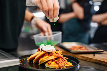 woman chef hand cooking pancakes with meat, bacon and cheese sauce