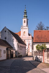 Fototapeta na wymiar Pink church a the end of the street in the small baroque city of Varazdin in Europe, surrounded by small houses 