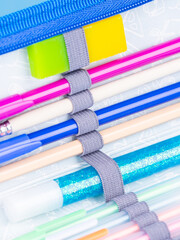 Close-up of stationery pens, pencils and felt-tip pens attached in a school pencil case