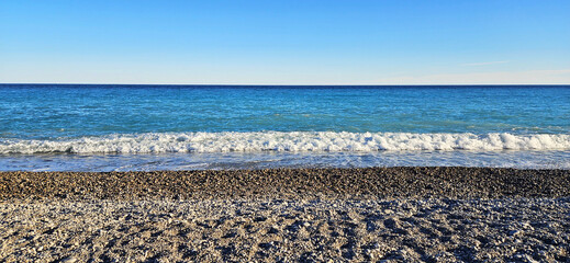 View of the sea, the sky and the pebble beach before sunset. Nice city view, French Riviera, France	
