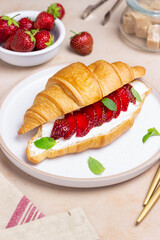 Croissant with strawberries, white cheese and mint. Breakfast. Vegetarian food.