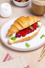 Croissant with strawberries, white cheese and mint. Breakfast. Vegetarian food.
