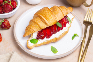 Croissant with strawberries, white cheese and mint. Breakfast. Vegetarian food.