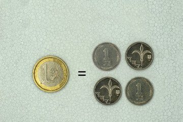 A coin of one euro is equal at the exchange rate to four coins of one new Israeli shekel - obrazy, fototapety, plakaty