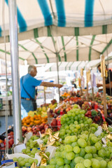 Grape on stall with selling fruit, food market, customers in blurred background