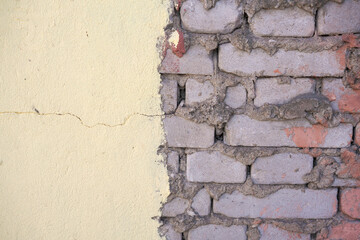 texture of a wall painted with peeling paint to a brick