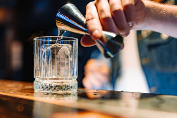 man bartender hand making negroni cocktail. Negroni classic cocktail and gin short drink with sweet vermouth, red bitter liqueur
