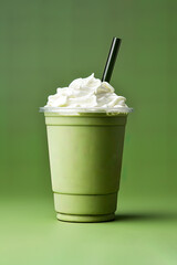 Green tea frappucino with whipped cream in a takeaway cup isolated on green background