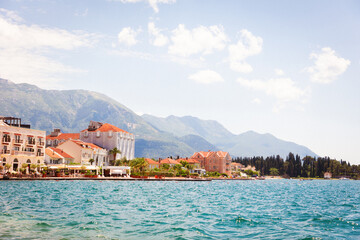 Fototapeta premium View from sea to sunny European town. Mountains in background. Travel and summer. Copy space. Adriatic land