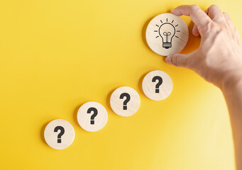 Hand hold wood block to smart creativity light bulb which among question icon. smart, creative,...