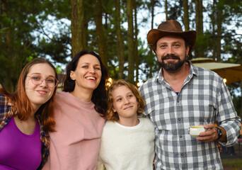 Family members father, mother and two daughters in camping in the forest