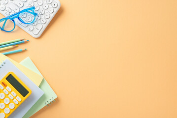 Start school year in style with enticing top view image. Neatly arranged school supplies, glasses, keyboard, planners, calculator, pencils on soft orange backdrop, allowing space for custom text or ad