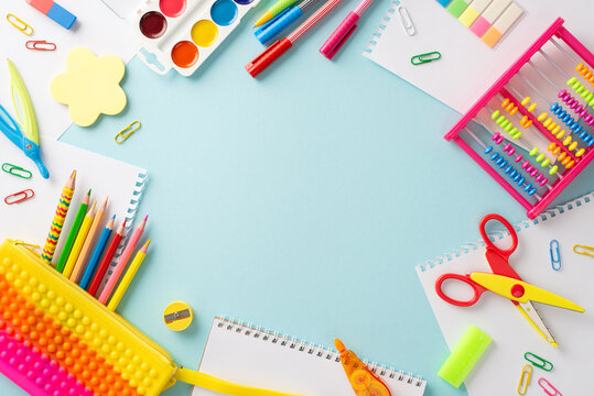 Explore the wonders of education for young learners: top view photo showcasing an assortment of vibrant school supplies on a pastel blue isolated background, with round frame for text or promotions