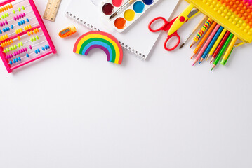 Explore wonders of early childhood education with this top-down perspective: arrangement of colorful child stationery on white isolated background, providing copyspace for text or promotional material