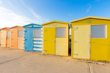 Fototapeta na wymiar Colourful beach huts in a row. Seaford, East Sussex