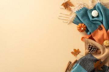 Capture charm of autumn with inviting setup: top view featuring soft plaid, small pumpkins, yellow...