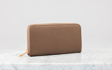 Luxury women 's handbag, wallet. Luxury dark brown leather handbag on white background, on marble...