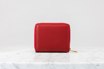 Luxury women 's handbag, wallet. Luxury red leather handbag on white background, on marble floor. The camera is right in front of wallet. Fashionable trendy accessory
