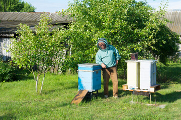 Portrain of Ukrainian smiling senior bee-keeper at work place