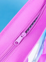 close-up of a zipper on a pink school pencil case on a blue background. Back to school. copy space © Виталий Сова