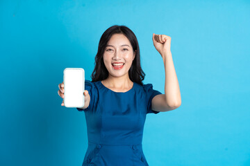 Portrait of beautiful woman in blue dress, isolated on blue background.