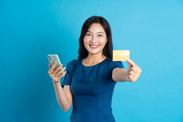 Portrait of beautiful woman in blue dress, isolated on blue background.